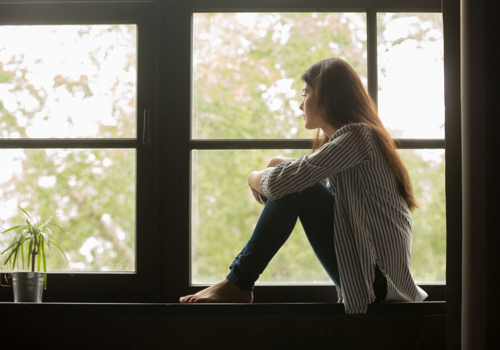 Grief young woman in window